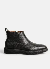 Bota corta de cuero negro con textura granulada, diseño de puntera reforzada y suela de goma gruesa con relieve estriado. Cuenta con cierre lateral y tirador en la parte trasera.