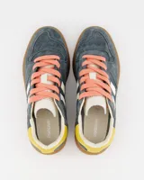 Championes urbanos Coolway modelo Goal, color azul con detalles en amarillo y marrón. Confeccionados en serraje suave con detalles en contraste de color, lengüeta preformada de piel con acolchado figurado, forro interior en piel, cordones planos de algodón bicolor intercambiables, cuello ligeramente acolchado y puntera reforzada con pespuntes decorativos. Suela flexible de goma y caucho. Nombre del modelo “GOAL” en tono oro envejecido en el lateral.