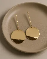 Aros colgantes de diseño minimalista compuestos por una barra vertical fija y un dije circular liso con acabado brillante.