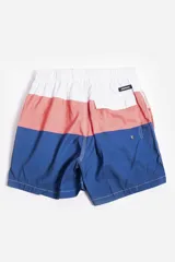 Short de baño celeste con estampado de hojas pequeñas en tonos verdes y blancos. Cuenta con cintura elástica con cordón ajustable, bolsillos laterales y un parche circular con logo en la parte inferior.