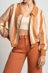 Cárdigan tejido con cierre frontal, diseño a rayas horizontales en tonos naranja, beige y rosa, cuello tipo polo y mangas abullonadas.