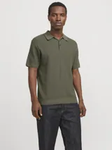 Polo de manga corta confeccionado en tejido de punto estructurado con textura sutil. Presenta cuello clásico, cierre frontal con botones y terminaciones acanaladas en mangas y ruedo.