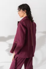 Blazer corto color chocolate de lino con solapas de muesca, cierre frontal con dos botones, bolsillos de parche y ribete en contraste color crema.