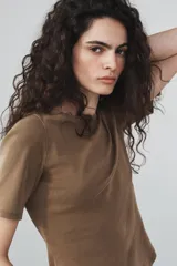 Camiseta de algodón color terracota con efecto lavado, cuello redondo y manga corta. Posee un bajo redondeado.