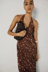 Vestido midi satinado color marrón con estampado de lunares difuminados, de cuello halter con tiras ajustables para atar en la espalda y escote en V.