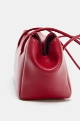 Bolso de hombro en formato alargado de diseño minimalista, con doble asa larga y cierre imantado. Cuenta con un bolsillo interior con cremallera.