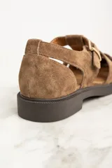 Sandalias cangrejeras de gamuza color marrón con hebilla dorada.