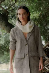 Tapado de corte recto y largo midi, confeccionado en tejido con textura de espiga en tonos grises. Presenta solapas clásicas, cierre frontal con botones y bolsillos laterales amplios con solapa.