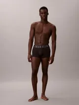 Pack de tres boxers ajustados de corte trunk marca Calvin Klein, modelo Intense Power. Confeccionados en mezcla de algodón y elastano de color negro, cuentan con una llamativa cinturilla elástica distintiva con el logotipo de la marca en colores gris, azul y blanco.