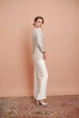 Pantalón palazzo color crudo con textura arrugada y cintura elástica.