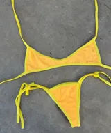 Conjunto de bikini con corpiño triangular y bombacha cavada con tiras finas.