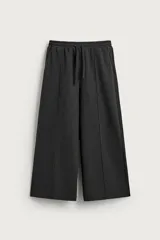 Pantalón jogger wide fit de color gris oscuro, confeccionado en tejido con acabado cepillado. Cuenta con cintura elástica ajustable con cordón, bolsillos delanteros y detalle de nervios frontales en las piernas.