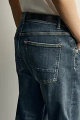 Jeans skinny fit de color azul, con efecto lavado y detalles de roturas en las piernas. Diseño de cinco bolsillos, tiro medio y cierre frontal con cremallera y botón.