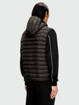 Chaleco acolchado negro con capucha, cierre frontal y diseño híbrido que combina paneles de nylon con mangas de tejido tipo buzo con detalles de líneas blancas.