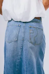 Pollera larga de denim azul con diseño en paneles y corte evasé, con terminación deshilachada en el ruedo.
