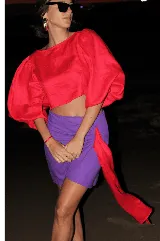 Falda corta de lino con lurex negro y plateado, de diseño cruzado estilo pareo con cierre invisible lateral y detalle de lazo asimétrico.