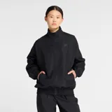 Campera deportiva New Balance, color negro, con cierre frontal y cuello alto. Presenta un corte holgado con puños y cintura elásticos. Logo New Balance bordado en tono oscuro en el pecho.