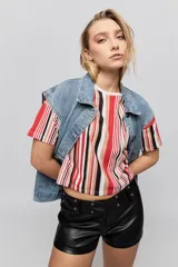 Short de tiro medio confeccionado en poliuretano color negro, con calce al cuerpo, cierre frontal y presillas con detalles de ojales metálicos.