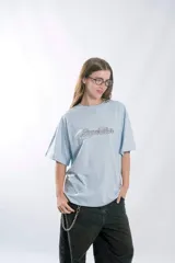 Remera de manga corta, corte oversize, color celeste claro, con la palabra "Superstar" bordada en el pecho en tipografía cursiva con contorno negro.