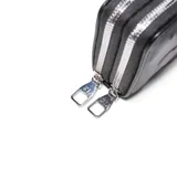 Billetera XL de doble compartimento en color negro, con diseño de corazones grabados en relieve y logo metálico plateado en el frente.