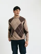 Sweater de punto con diseño de rombos en gris y azul marino, escote redondo a la base, manga larga y terminaciones en punto acanalado en cuello, puños y ruedo.