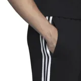 Pantalón de jogging Adidas modelo Essentials, color negro con las icónicas tres bandas blancas laterales. Presenta cintura elástica con cordón ajustable, corte cónico y puños acanalados en los tobillos.