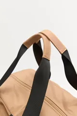 Bolso de nylon en color verde militar, con diseño deportivo, asas de mano resistentes, cierre superior y bolsillos laterales con frunce ajustable mediante cordón elástico.