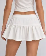 Falda corta blanca con cordón ajustable en la cintura y volados en el borde inferior.