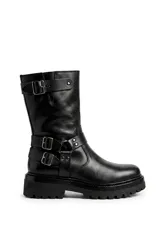 Bota de cuero negro de caña media, con suela track y plataforma gruesa. Cuenta con detalles de tiras con hebillas metálicas en el tobillo y en la parte superior de la caña.