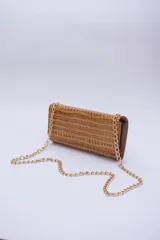 Cartera tipo sobre color beige con textura granulada y correa de cadena dorada.