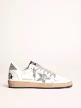 Zapatillas Golden Goose Ball Star de cuero blanco con estrella plateada brillante, refuerzo trasero plateado brillante, cordones grises y suela color caramelo.