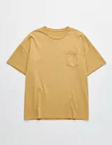 Remera de algodón color mostaza, con cuello redondo, mangas cortas y bolsillo frontal con pequeño bordado.