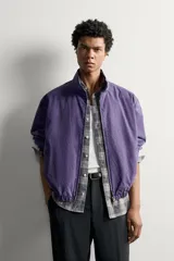 Cazadora relaxed fit de algodón en color violeta, con efecto lavado, cuello subido, cierre frontal con cremallera y bolsillos de vivo en la cadera.