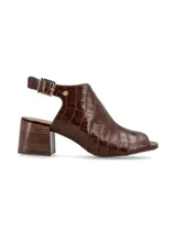 Sandalia de mujer color marrón oscuro, con textura de cocodrilo (croco) y punta abierta. Presenta un diseño tipo botín abierto con tira ajustable con hebilla dorada en el tobillo y taco ancho de altura media.
