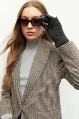 Guantes negros con diseño de cuero sintético en la palma y tejido de punto en el dorso.