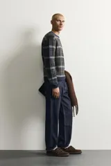 Pantalón de jean corte slim fit con efecto lavado, tiro medio, cinco bolsillos y cierre frontal con cremallera y botón.