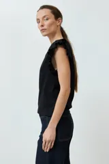 Top de punto canalé color fucsia, con cuello redondo y mangas cortas con volados decorativos en los hombros.