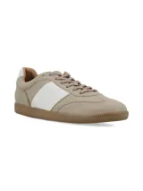 Championes de cuero color beige con franja lateral blanca, cordones al tono y suela de goma color caramelo.