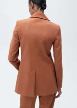 Chaqueta de estilo sastre color tostado, con cuello de solapa, cierre frontal de botón, manga larga y tres bolsillos de parche frontales. Presenta un diseño entallado con forro interior.