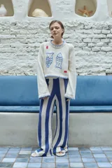 Pantalón de tejido crochet a rayas verticales azules y blancas.
