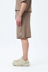Bermuda marrón de algodón y poliéster, corte relajado, tiro medio, cordón ajustable en la cintura y estampado con inspiración college.