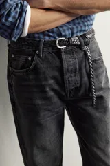 Jeans straight fit de corte recto y tiro medio, confeccionados en denim de algodón rígido con efecto lavado en color negro, de la colección especial Aaron Levine x Zara. Presentan diseño clásico de cinco bolsillos y cierre frontal con botonadura.