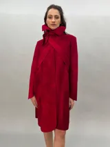 Tapado rojo de lana merino afieltrada, corte recto con lazos para ajustar en la cintura y cuello alto con posibilidad de cruzar los lazos alrededor. Tiene bolsillos laterales.