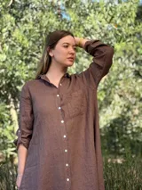 Vestido camisero color beige claro, de lino 100% natural, con botones de nácar, bolsillo delantero y mangas 3/4 con botón para recogerlas. Diseño asimétrico, más largo en la parte trasera.
