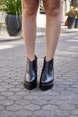 Botinetas de cuero negro con taco ancho, plataforma delantera y diseño con boca en V en el tobillo.