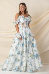 Vestido largo de fiesta en gasa de seda natural color blanco con estampado de flores celestes y verdes. Corsé strapless con ballenas y detalle de flores en escote y mangas caídas. Espalda cruzada y falda amplia con tajo delantero.