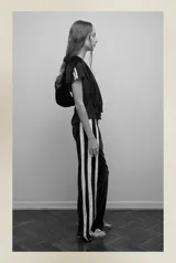 Pantalón de terciopelo negro con bandas laterales blancas, cintura elástica y botamanga recta.