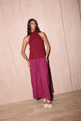 Vestido largo negro de crepe texturado con escote halter, cuello alto con volados y diseño holgado.