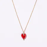 Colgante con cadena dorada y dije de frutilla de cristal rojo con detalles verdes en la parte superior y bolitas doradas en la base.
