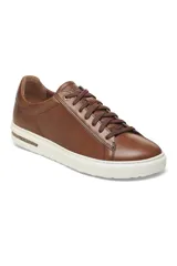 Zapatillas de cuero color cognac, con cordones marrones y suela blanca.